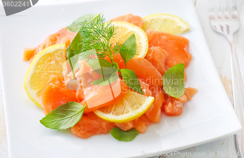 Image of fresh salmon with lemon on the white plate