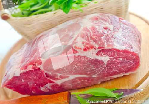 Image of raw meat and knife on the wooden board