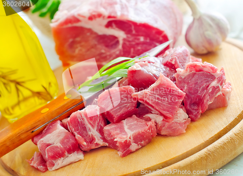 Image of raw meat and knife on the wooden board