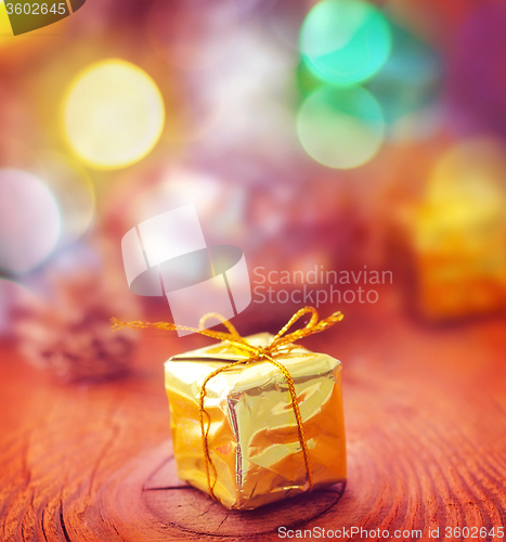 Image of Gold present and cristmas decoration on the wooden board