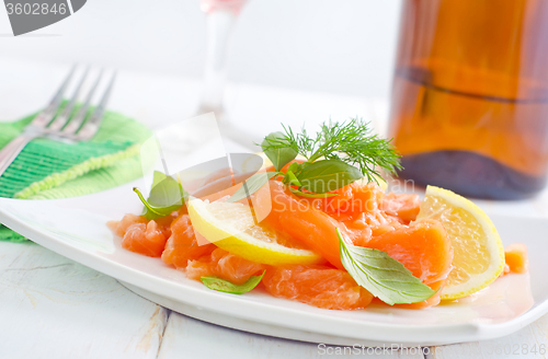 Image of fresh salmon with lemon on the white plate