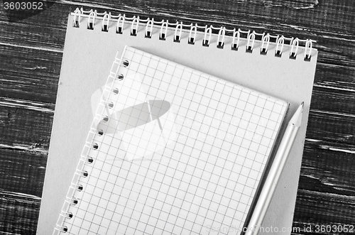 Image of note and pencil on wooden background