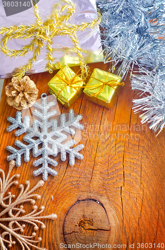 Image of Cristmas decoration on the wooden background, present and snowfl