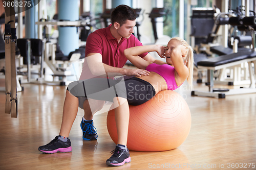 Image of young sporty woman with trainer exercise in fitness gym