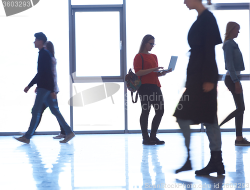 Image of student girl standing with laptop, people group passing by