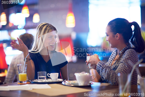 Image of girls have cup of coffee in restaurant