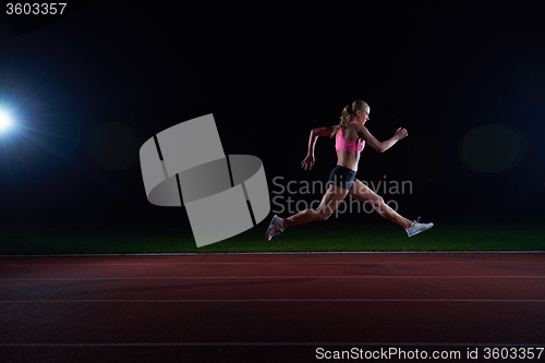 Image of Athletic woman running on track