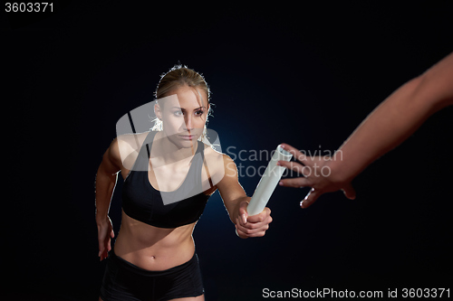 Image of athletic runners passing baton in relay race