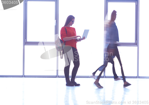 Image of student girl standing with laptop, people group passing by