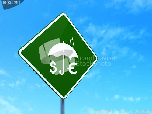 Image of Protection concept: Money And Umbrella on road sign background