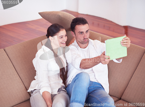 Image of couple at modern home using tablet computer