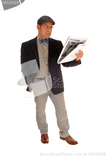 Image of Man standing and reading the newspaper.