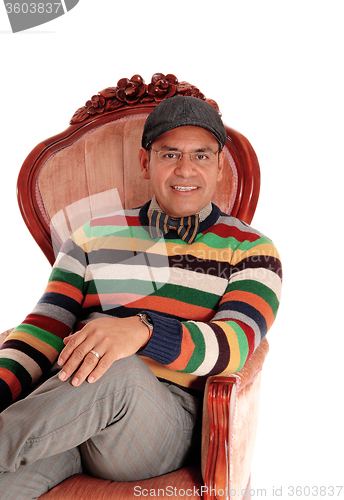 Image of Happy middle age man sitting in armchair.