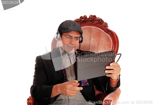 Image of Man listening from his tablet.