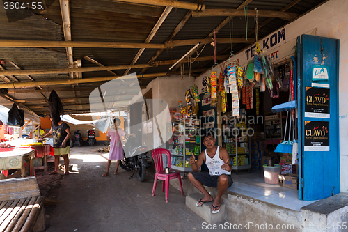 Image of Indonesian man in front of his store in Manado shantytown