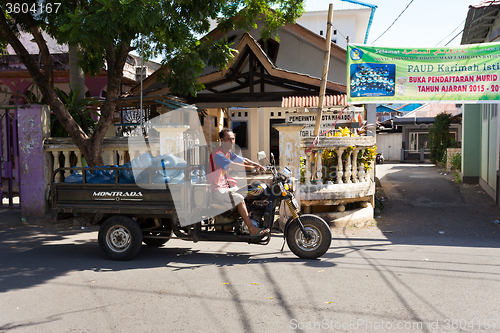 Image of Man transport water botles in the streets of Manado
