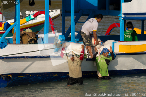 Image of Men transports cargo from ship