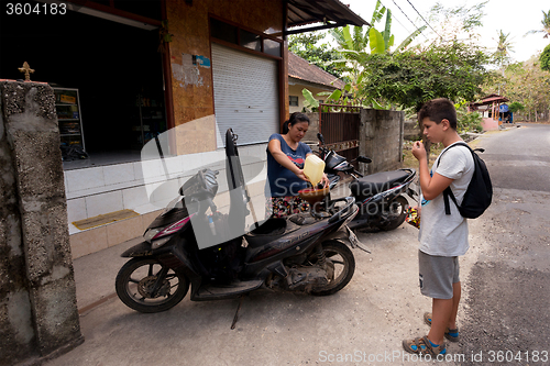 Image of Woman sell benzine in plastic bottle