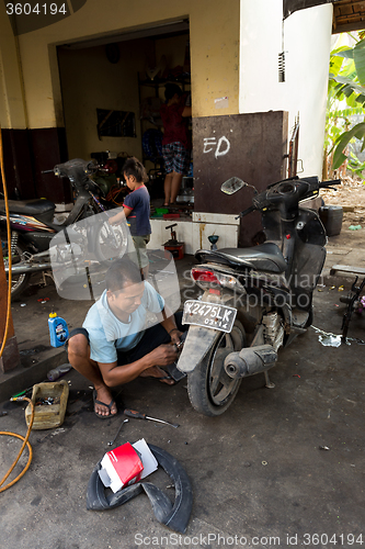Image of Service man repair deflated damaged tyre