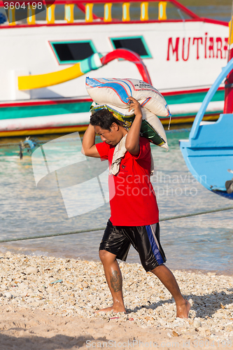 Image of Men transports cargo from ship