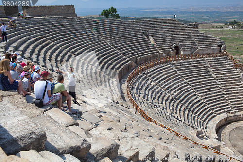 Image of Guide and tourists in ancient amphitheater