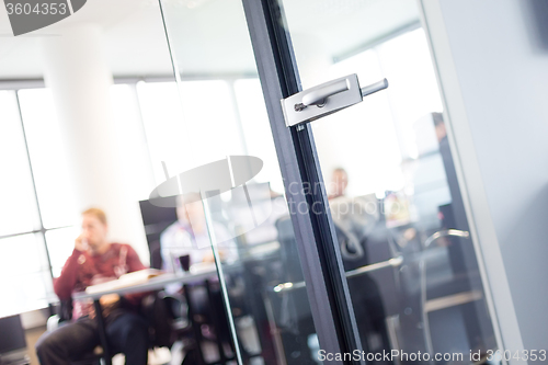 Image of Trough glass door view of corporate meeting.