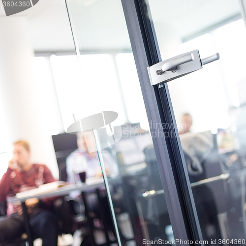 Image of Trough glass door view of corporate meeting.