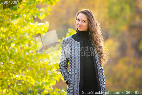 Image of Cute young girl on the background of the autumn yellow foliage