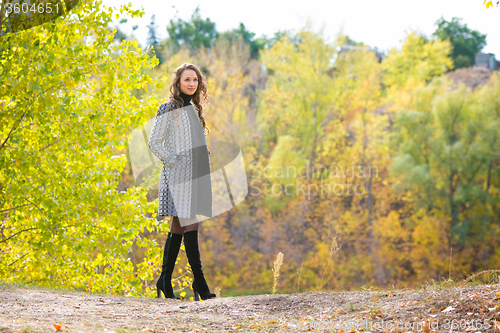 Image of Young girl walking in the autumn forest