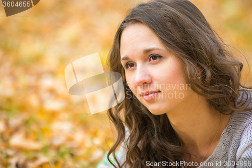 Image of Close-up portrait of a beautiful young girl on the blurry background yellow foliage