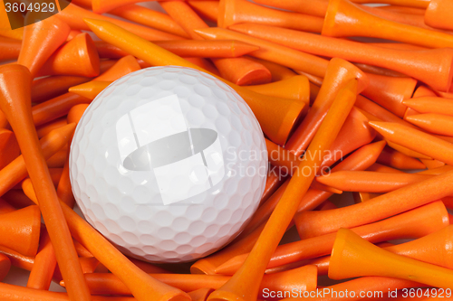 Image of White golf ball lying between wooden tees