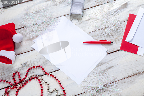 Image of The blank sheet of paper on the wooden table with a pen 