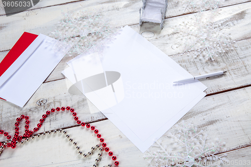 Image of The blank sheet of paper on the wooden table with a pen 