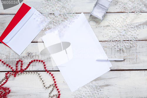 Image of The blank sheet of paper on the wooden table with a pen 