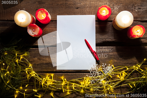 Image of The blank sheet of paper on the wooden table with a pen 