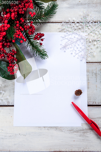 Image of The blank sheet of paper on the wooden table with a pen 