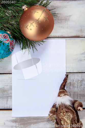 Image of The sheet of paper on wooden table with Christmas decorations 