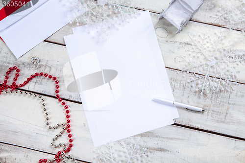 Image of The blank sheet of paper on the wooden table with a pen 