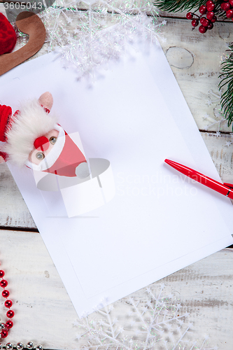 Image of The blank sheet of paper on the wooden table with a pen 