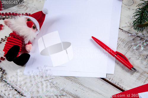 Image of The blank sheet of paper on the wooden table with a pen 