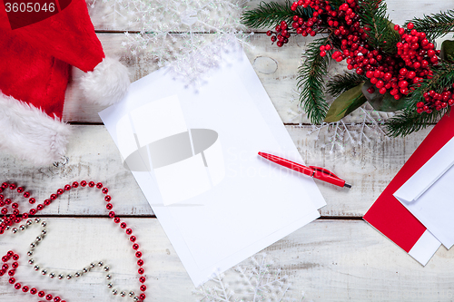 Image of The blank sheet of paper on the wooden table with a pen 