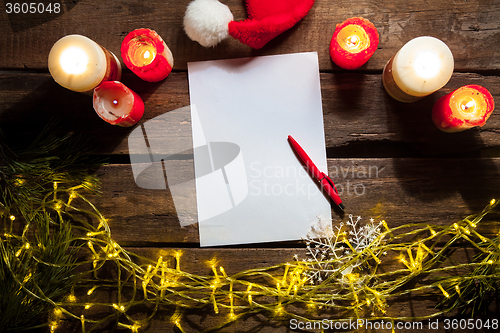 Image of The blank sheet of paper on the wooden table with a pen 