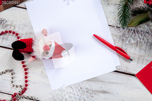 Image of The blank sheet of paper on the wooden table with a pen 