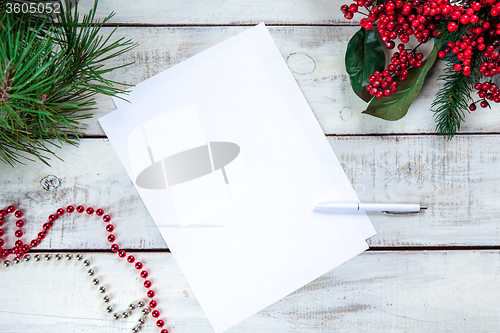 Image of The blank sheet of paper on the wooden table with a pen 