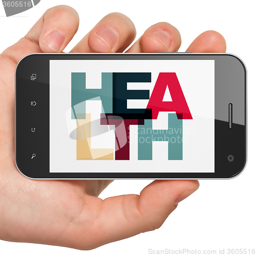 Image of Health concept: Hand Holding Smartphone with Health on  display