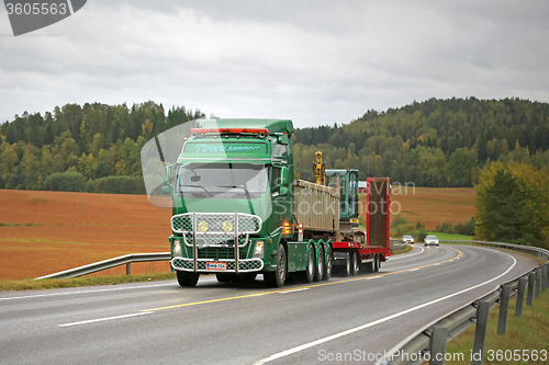 Image of Green Volvo FH Hauls Yanmar Mini Excavator 