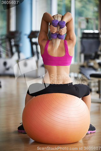 Image of lifting some weights and working on her biceps in a gym