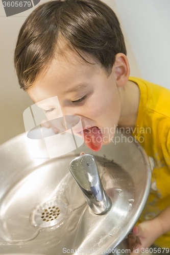 Image of Mixed Race Boy Drinking From the Water Fountain