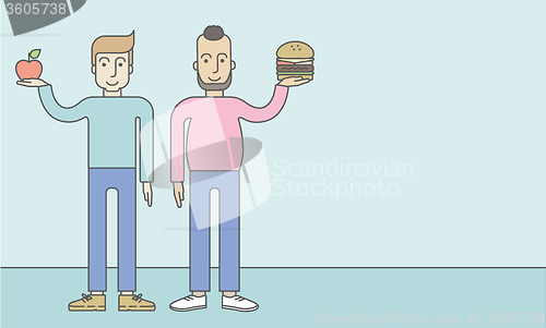 Image of Men standing with hamburger and apple.