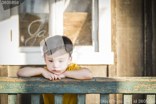 Image of Melancholy Mixed Race Boy Leaning on Railing